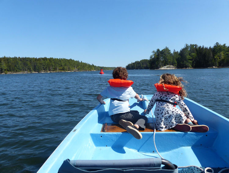 Zev and Lucie, grand-nephew and grand-niece, in bow of Boston Whaler cruising up river